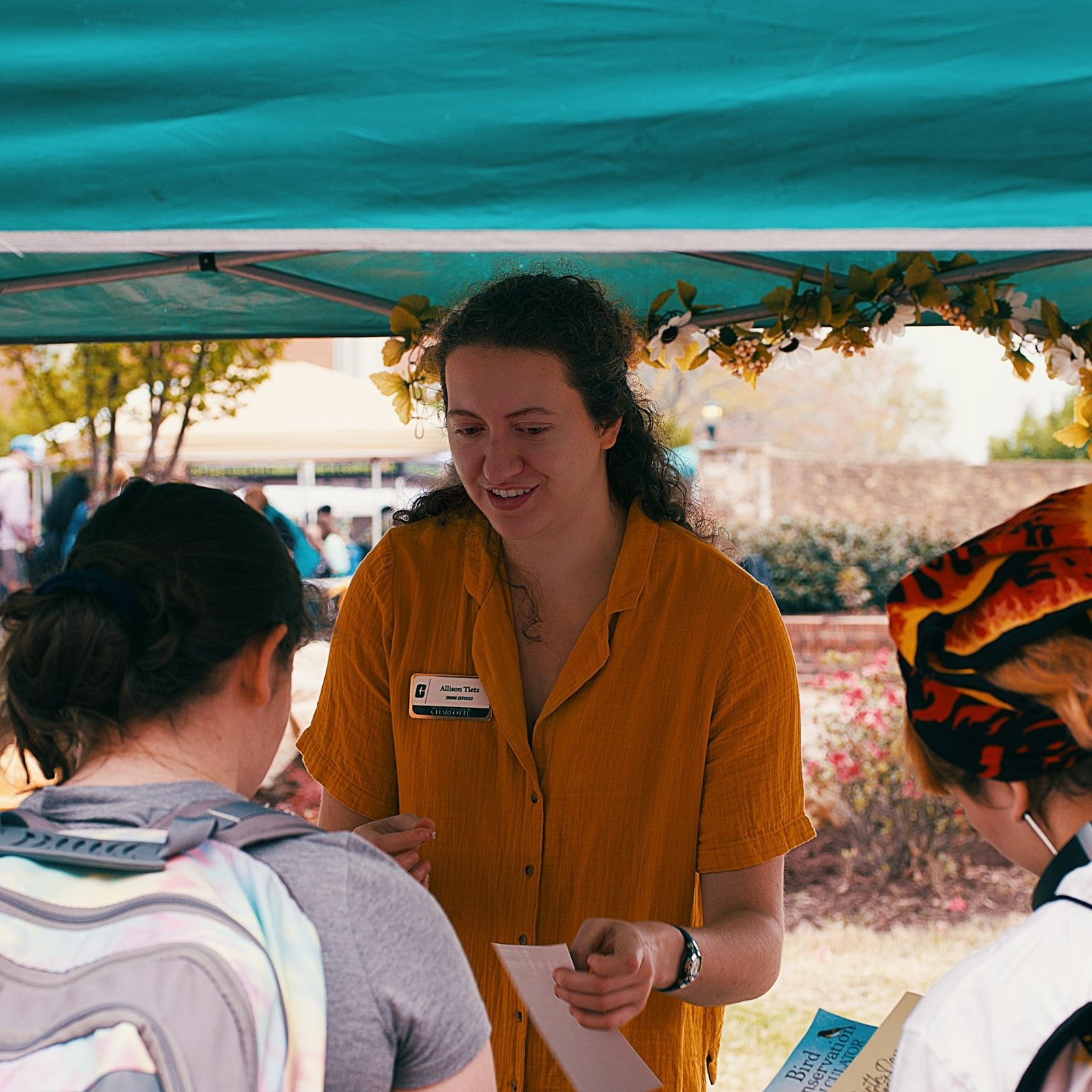 A volunteer handing out information at a community table